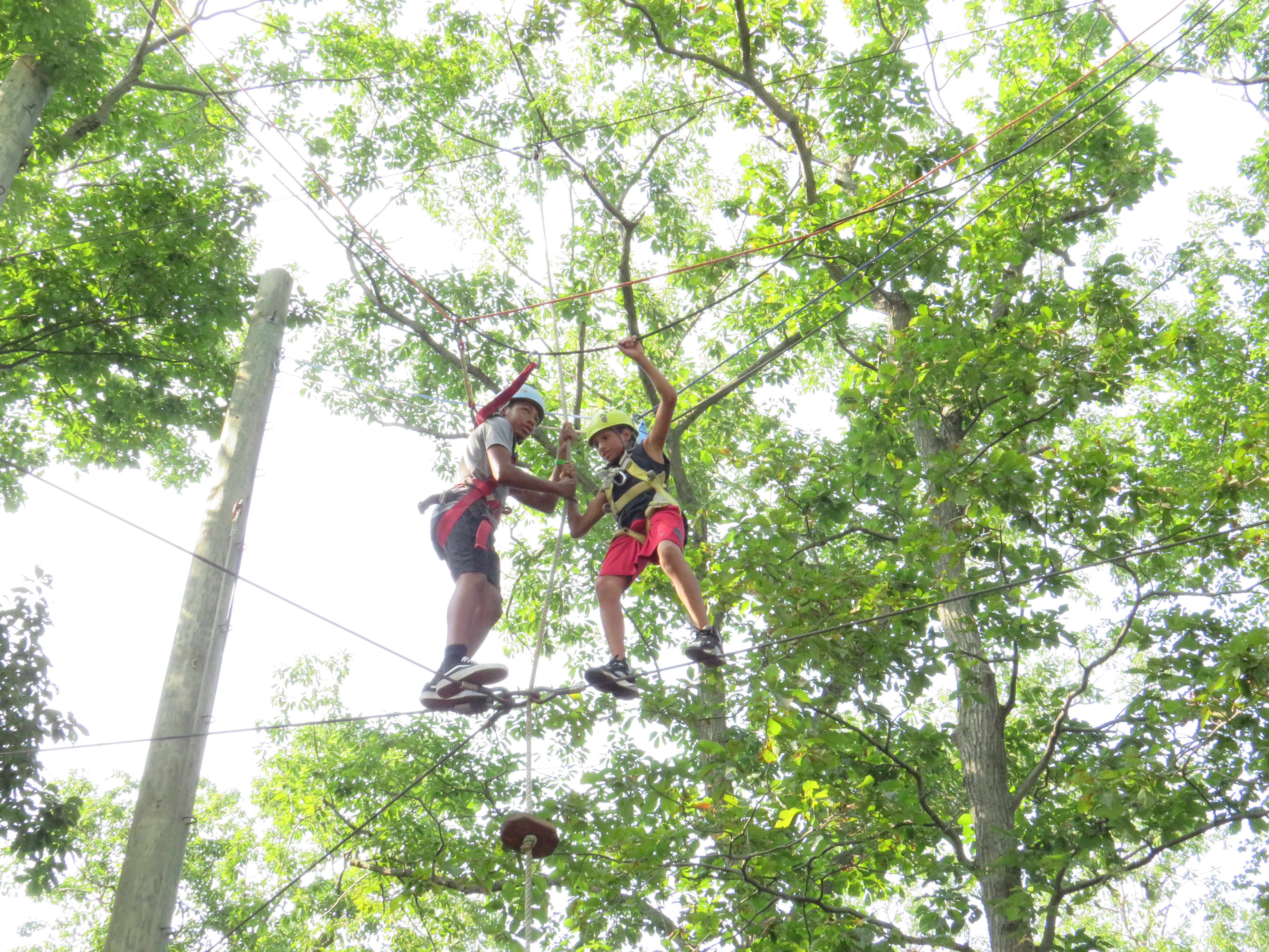 Campers conquering an obstacle on the ropes course